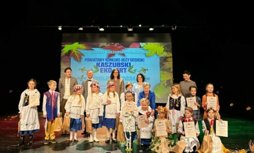 Zdjęcie grupowe dzieci w strojach ludowych na scenie